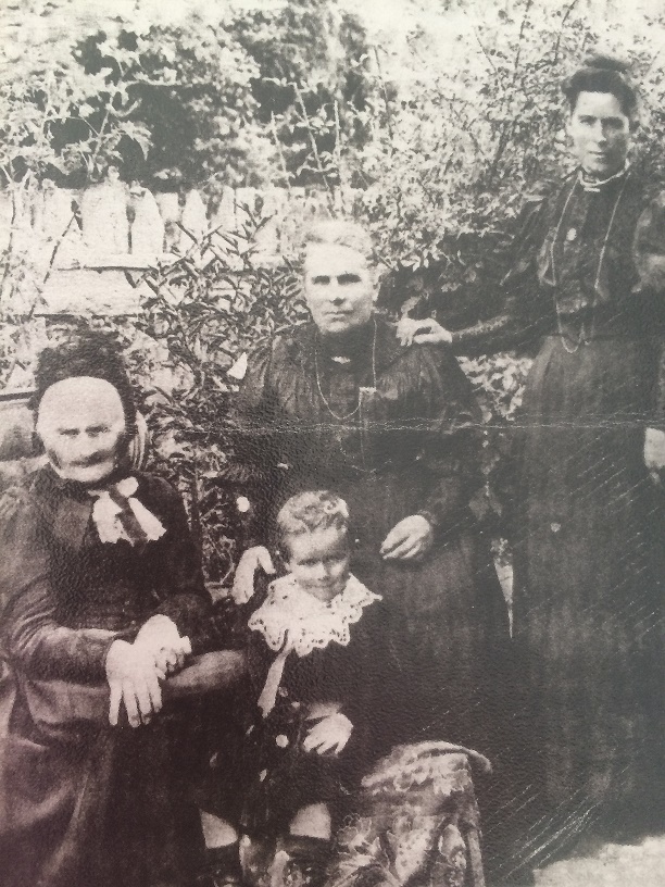 Taken not long before her death. Hannah Ann seated with daughter, Emily Warne, granddaughter, Emily Alice Waddell, and great grandson Snowy Norman.
